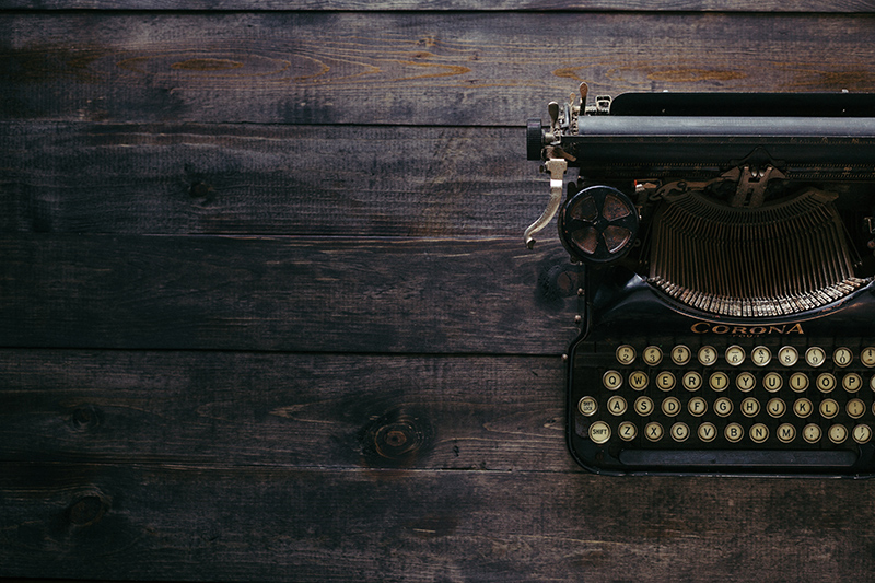 Old manual typewriter on a wooden desk.