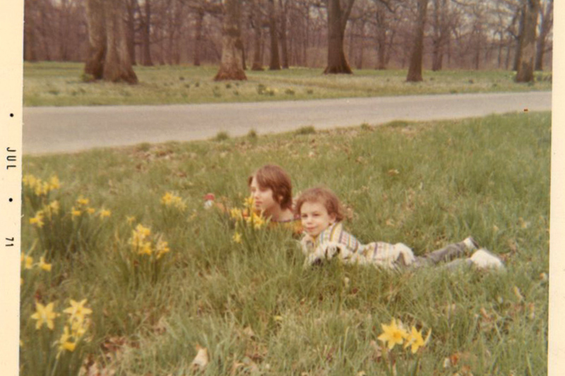 My sister and my pancho-ed self in the grass (1971)