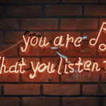 Neon sign reading "You are what you listen to."