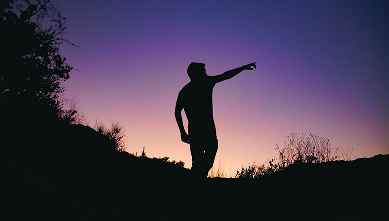 Person pointing at the sky.