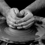 Hands shaping a bowl on a potter's wheel