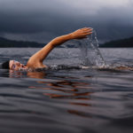A woman swimming across a lake