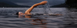 A woman swimming across a lake