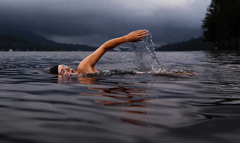 A woman swimming across a lake