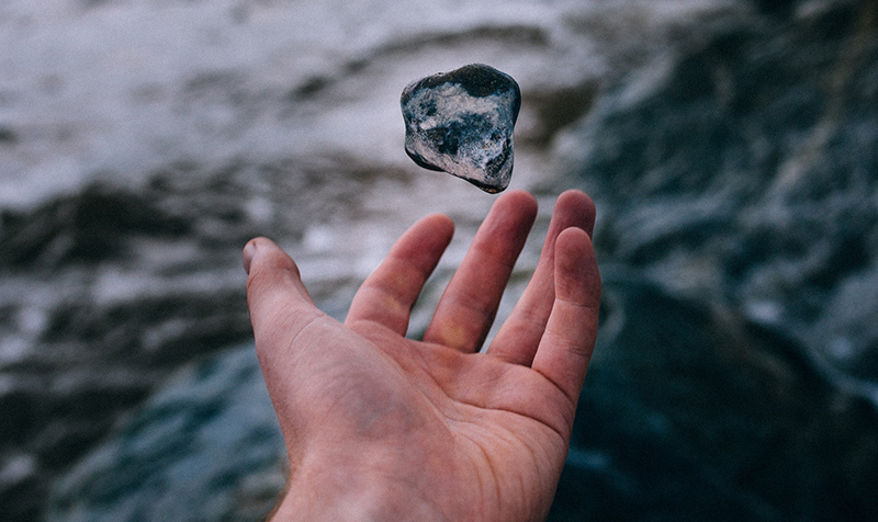 Hand tossing a stone in the air